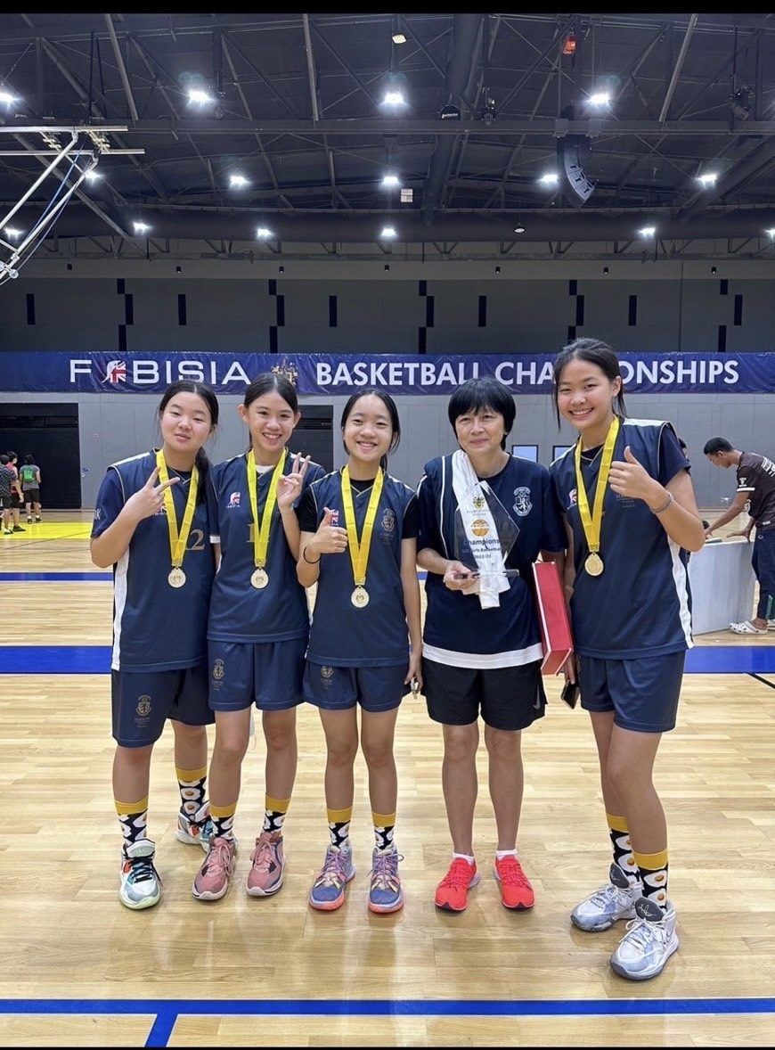 Junior Varsity basketball team with medals at FOBISIA