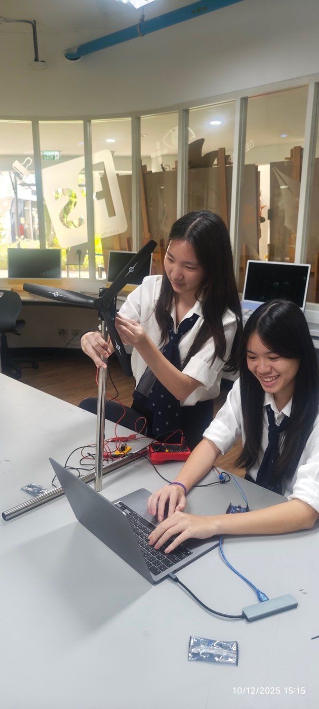 Adjusting the wind turbine prototype while logging data on a laptop